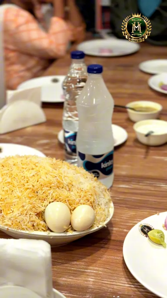 A plate of biryani with boiled eggs on a table at Madina Hotel, mid-meal